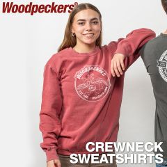 A woman in the Woodpeckers crimson crew neck sweatshirt with the old bird logo leaning against a man with a Woodpeckers T-shirt.