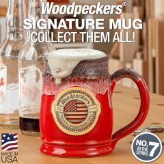 The 23 ounce Woodpeckers Tankard mug sitting on a workbench with the bulk of two root beer bottles emptied into the mug and foam over-spilling the top. 
